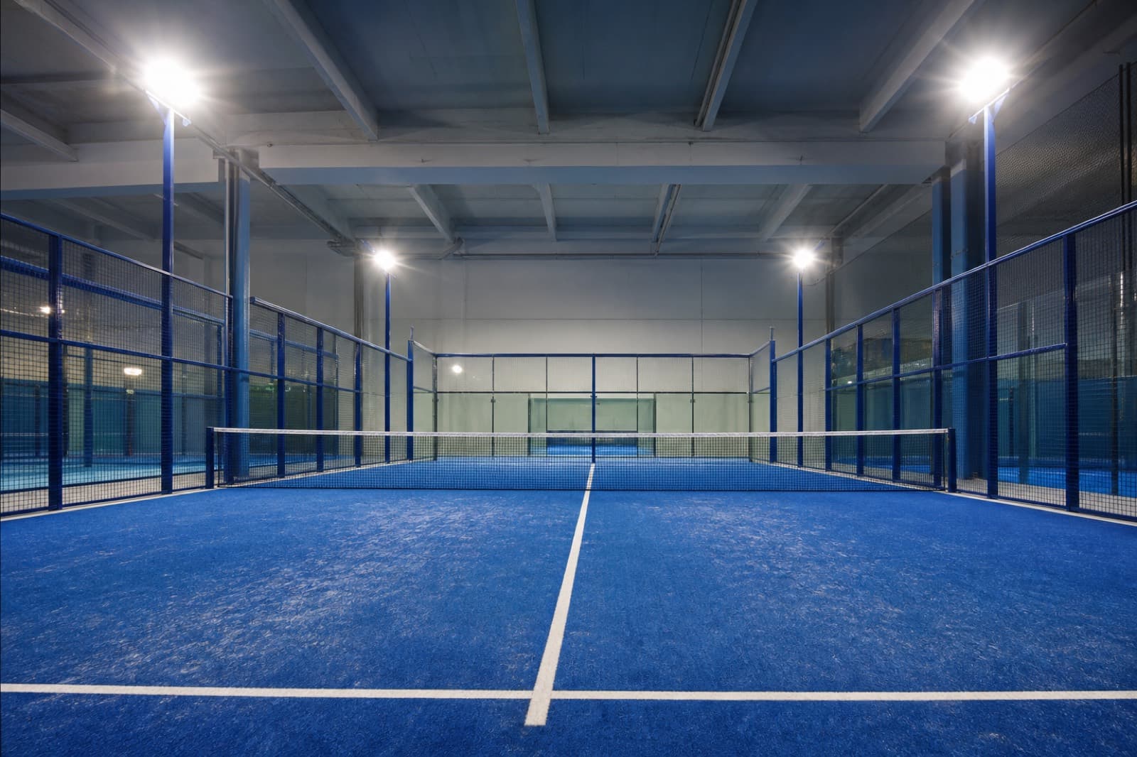 Indoor padel court with blue glass walls